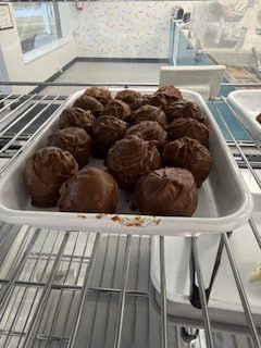 A picture of Chocolate Chip Doughlettes, which are cookie dough balls dipped in chocolate, inside the merchandise case.