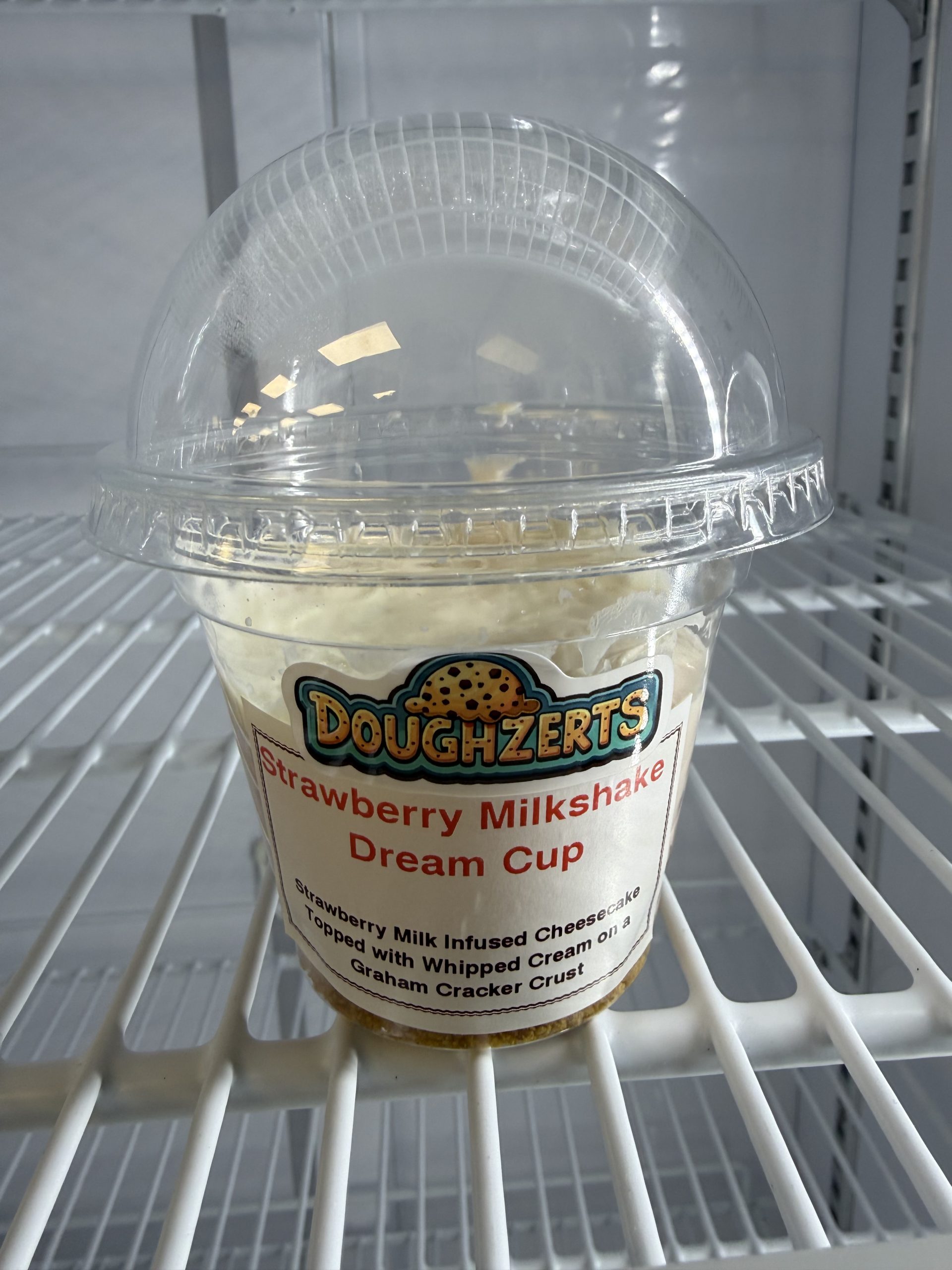 A picture of the Strawberry Milkshake Dream Cup, a no bake strawberry cheesecake style dessert, located in the drink refrigerator.
